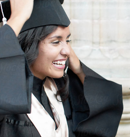 A young woman in a cap and gown about to graduate from Saint Augustine College.